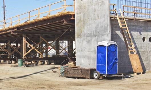 a row of blue porta potties set up on a work site